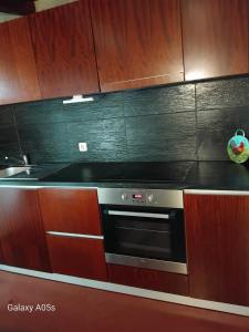 a kitchen with a black oven and wooden cabinets at Casa Portela in Marialva +4 photos