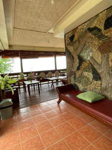 a room with a bench and a wall with a tree on it at 74YOU Beach Resort and Restaurant in Puerto Princesa City