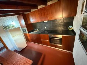 a kitchen with wooden cabinets and a white refrigerator at Casa Portela in Marialva