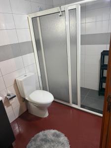 a bathroom with a toilet and a shower with a rug at Casa Portela in Marialva