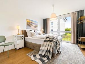 ein weißes Schlafzimmer mit einem Bett und einem Fenster in der Unterkunft Fewo Edel&Liebe Neubau mit Fahrstuhl, Parkplatz, Balkon, W-lan, ruhige Lage, Einkaufsmöglichkeiten 500m entfernt in Grömitz