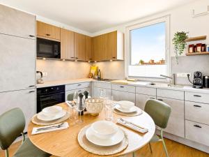 eine Küche mit einem Holztisch, auf dem Teller stehen in der Unterkunft Fewo Edel&Liebe Neubau mit Fahrstuhl, Parkplatz, Balkon, W-lan, ruhige Lage, Einkaufsmöglichkeiten 500m entfernt in Grömitz + 34 Fotos