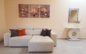 a living room with a white couch with pillows at Casa Sole - holiday apartment in Maccagno Superiore