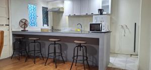 a kitchen with a counter with bar stools and a microwave at Casa céntrica en San Felipe in San Felipe