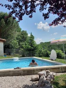 a man in a swimming pool in a yard at Les Cocons de Nabeillou in Graulhet