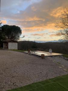 a backyard with a wooden table and a sunset at Les Cocons de Nabeillou in Graulhet
