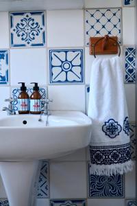 a white sink in a bathroom with blue and white tiles at Apartment Sapphire in Herolds Bay +21 photos