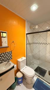 a bathroom with a toilet and a glass shower at Casa de praia da Michelly in Mangaratiba +27 photos