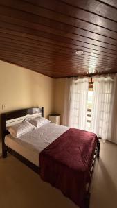 a bedroom with a large bed in front of a window at Casa de praia da Michelly in Mangaratiba