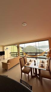a living room with a table and chairs and a large window at Casa de praia da Michelly in Mangaratiba