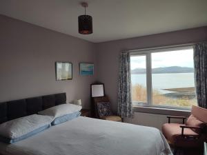 a bedroom with a bed and a large window at Tobar nan Iasgair Lismore in Achnacroish
