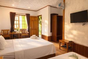 a hotel room with two beds and a flat screen tv at FORTUNE HOTEL 2 LUCKY STAY Phu Quoc in Phú Quốc