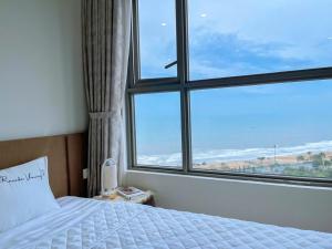 a bedroom with a bed and a large window at Căn hộ The Sóng Vũng Tàu Infinity Pool - Near Sea Tháp Tam Thắng in Vung Tau