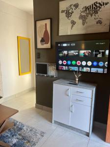 a room with a white refrigerator and a flat screen tv at Ekuku Snug in Oshakati