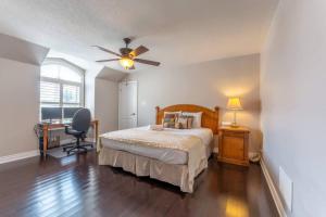 a bedroom with a bed and a ceiling fan at Spacious 7BR Home with Private Yard & Fast WiFi! in Brampton