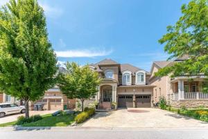 a large brick house with a driveway at Spacious 7BR Home with Private Yard & Fast WiFi! in Brampton