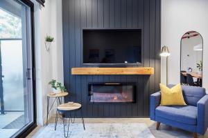a living room with a fireplace and a blue chair at Ripper Retreat in Revelstoke