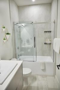 a white bathroom with a shower and a toilet at Ripper Retreat in Revelstoke +22 photos