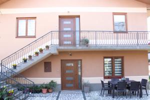 a house with a staircase and a table and chairs at Corner Five in Negotino