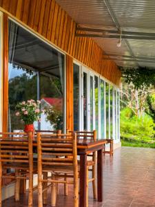 a porch with wooden benches and a vase of flowers at Bungalow Scent in Da Lat