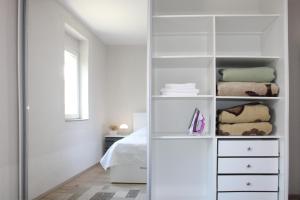 a white bedroom with a bed and a closet at Corner Five in Negotino
