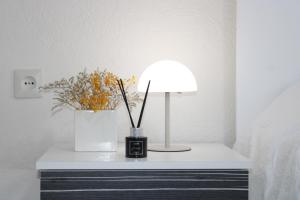 a bedside table with a lamp and flowers on it at Corner Five in Negotino