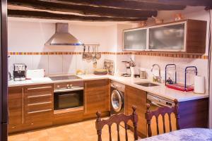 cocina con fregadero y fogones horno superior en B&B Casa Forcada, en Enate