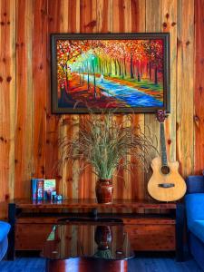 a living room with a tv and a guitar at Bungalow Scent in Da Lat