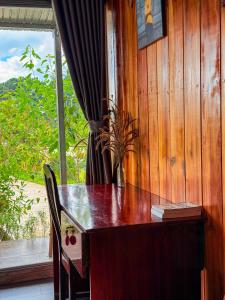 a wooden table in a room with a window at Bungalow Scent in Da Lat