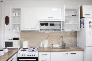 a kitchen with white cabinets and a sink and a stove at Corner Five in Negotino