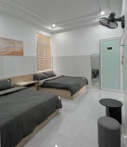 a bedroom with two beds and a table at Ancor Homestay in Phan Rang–Tháp Chàm
