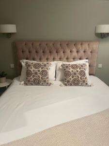 a large white bed with pillows and a large headboard at The Doonleigh suite in Ayr +6 photos