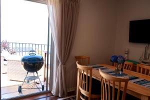 a dining room with a table and a large window at Apartment Sapphire in Herolds Bay