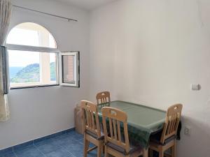 a dining room with a table and chairs and a window at Vila Pogled in Petrovac na Moru +27 photos
