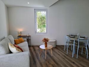 a living room with a couch and a table at Les Bords de l'Ouin - Mauléon - Proche PuyduFou - 4 personnes in Mauléon +2 photos