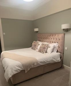 a bedroom with a large bed with white sheets and pillows at The Doonleigh suite in Ayr