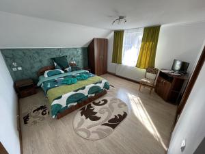 a bedroom with a bed and a desk in it at Casa Elena - vedere la munte in Bran +24 photos