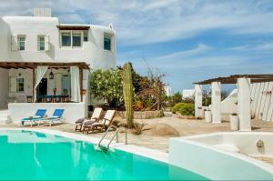 a villa with a swimming pool and a house at Villa ELAYA in Mikonos
