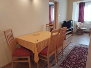 a dining room with a table and chairs at Nelly Apartman in Gheorgheni +7 photos