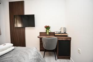 een hotelkamer met een bureau, een bed en een televisie bij Laurea Rooms in Split +31 foto's