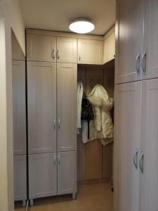 a closet with white cabinets and a light at Nelly Apartman in Gheorgheni