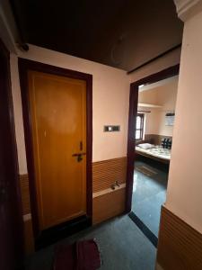 an empty room with a wooden door and a kitchen at Sri Devi Krupa in Hubli +6 photos