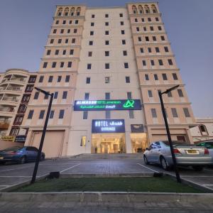 a large white building with a sign in front of it at Almasar Hotel in Maţār as Sīb ad Duwalī