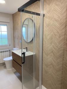 a bathroom with a shower with a sink and a mirror at Casa Ares in Cee