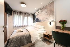 een kleine slaapkamer met een bed en een bureau bij Laurea Rooms in Split