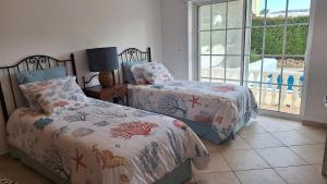 a bedroom with two beds and a window at Santos Villa in Quinta do Lago in Quinta do Lago +109 photos