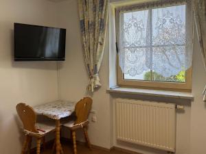 a room with a table and two chairs and a window at Ferienwohnung Haus Veronika in Wegscheid