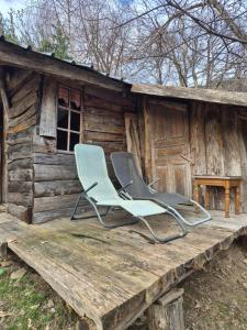 two chairs sitting on the porch of a cabin at Cabane en Cévennes in Saint-Germain-de-Calberte
