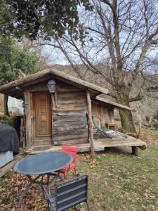 a table and chairs in front of a cabin at Cabane en Cévennes in Saint-Germain-de-Calberte