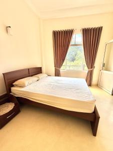 a large bed in a room with a window at Misty Hues in Kandy